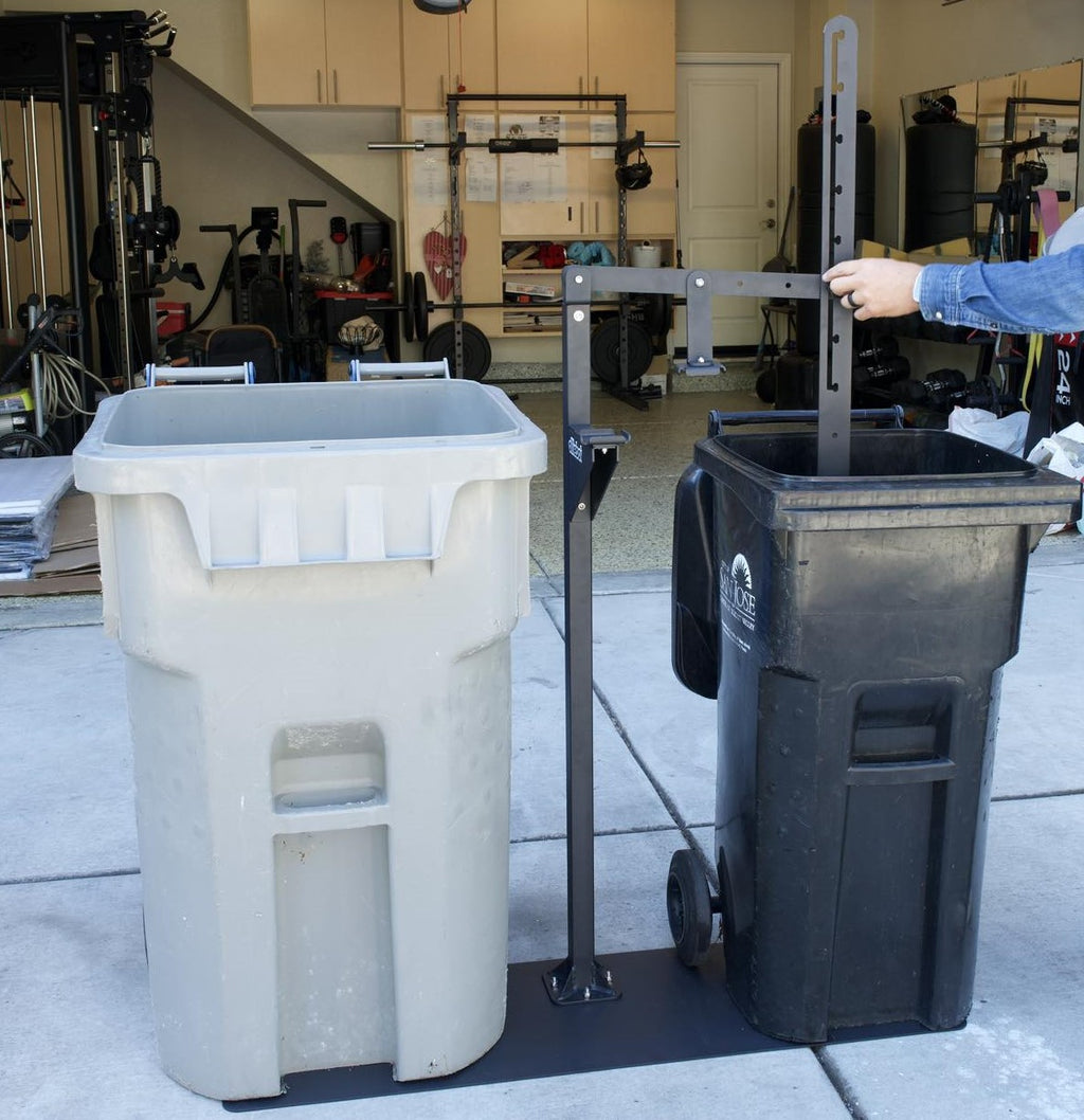 Manual Trash Compactor - Eco-Friendly Outdoors in use compressing waste in a black bin beside a gray trash can. Ideal for sustainable waste management.