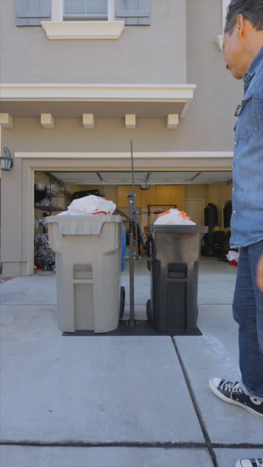 Manual Trash Compactor - Eco-Friendly Outdoors compressing garbage in two outdoor bins on a driveway. Ideal for sustainable waste management at home.